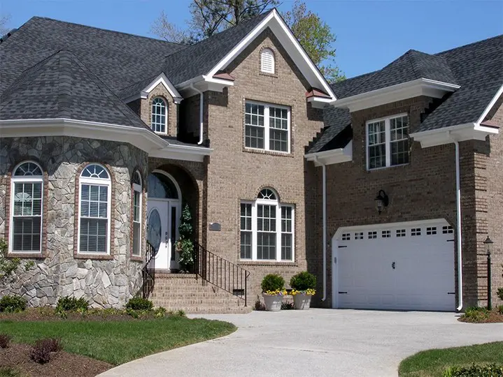 Villa with modern architecture and beautiful outdoor view A large brick house with two garage doors.